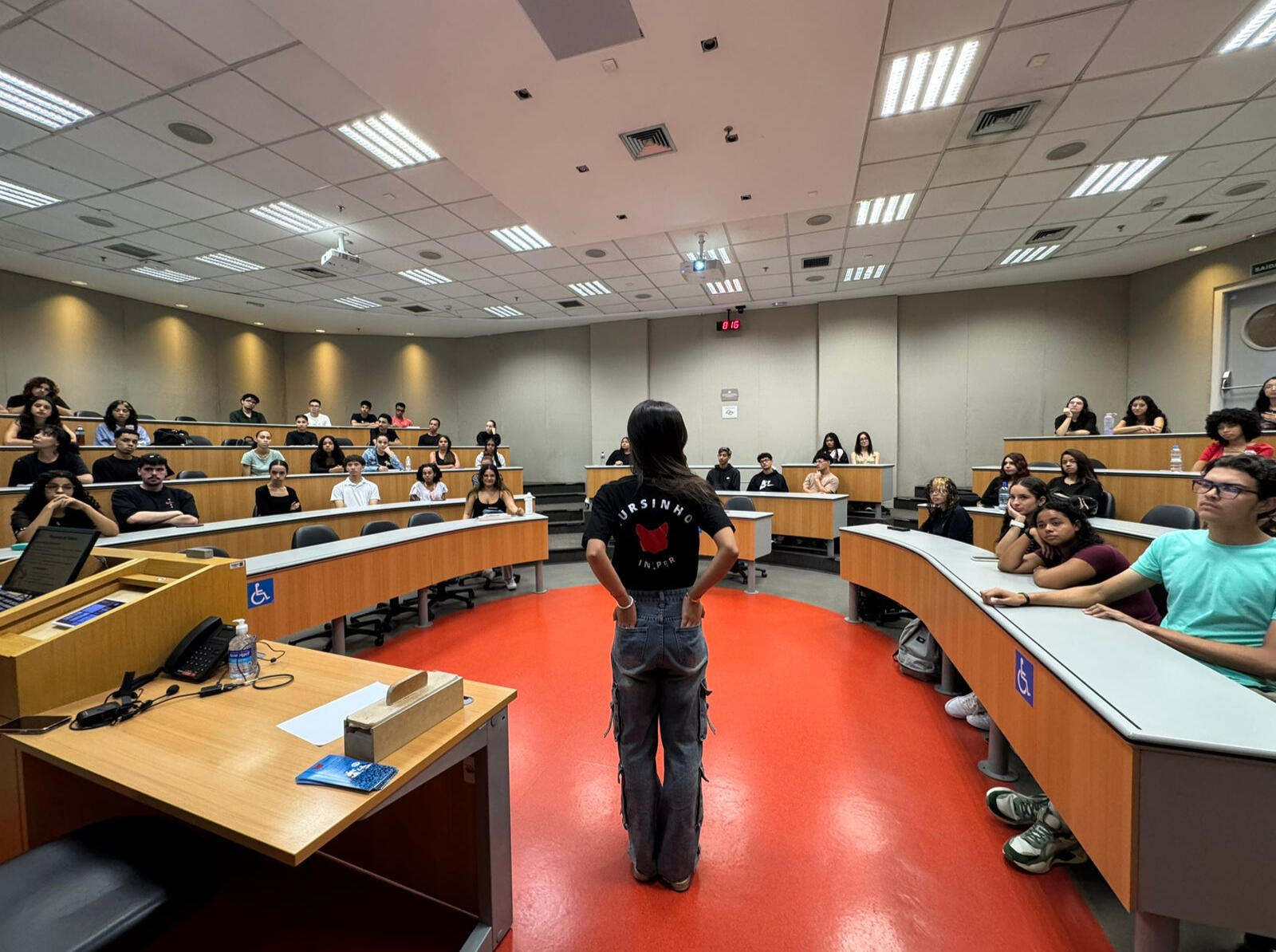 Alunos conversando e trabalhando com computadores em uma arquibancada